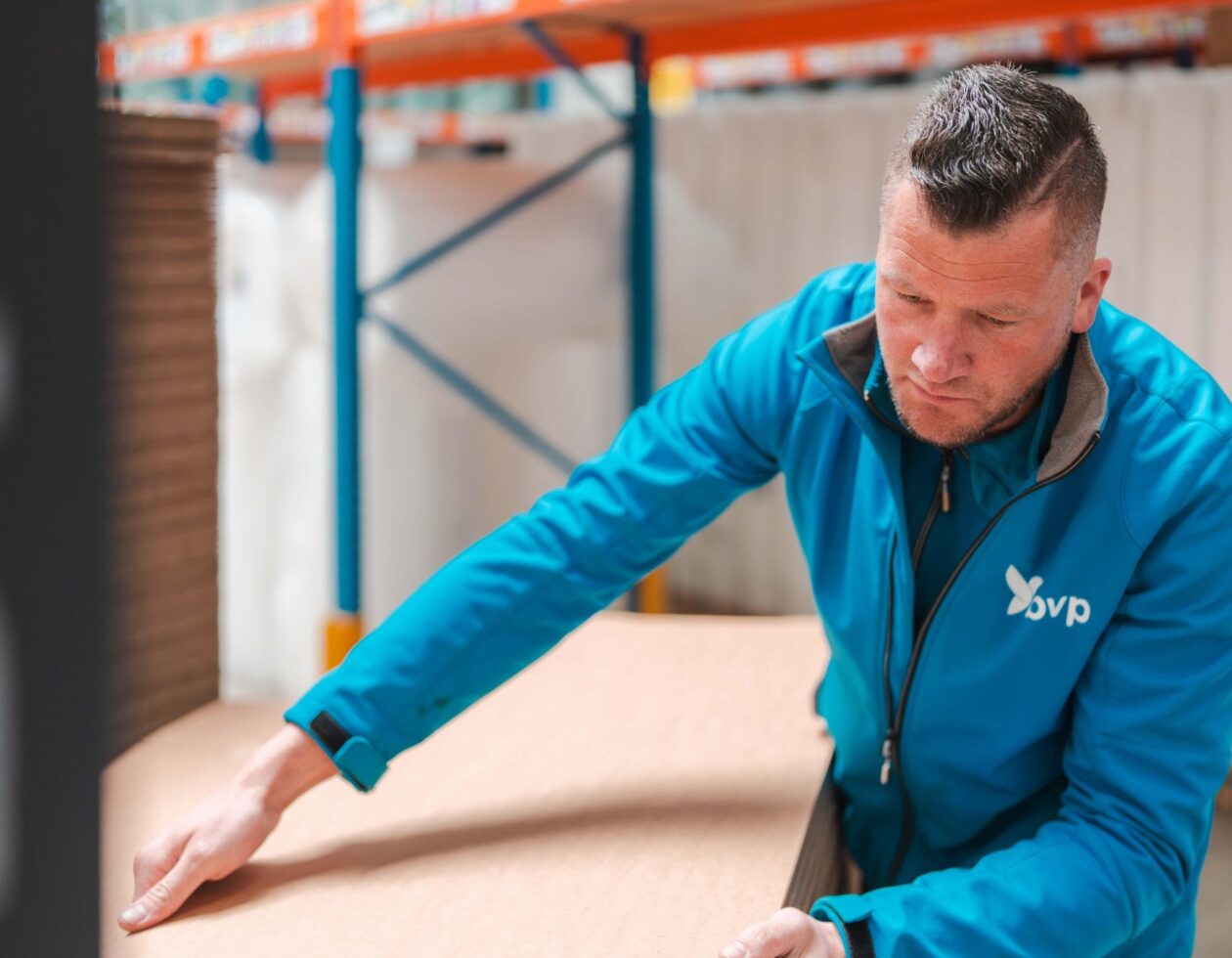 Medewerker van BVP Verpakkingen begeleidt een stapel kartonnen platen